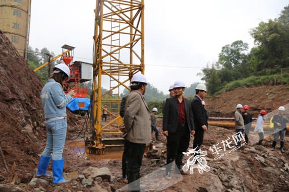 吴竹川(左三)带队在南川区撕栗坪水库工程现场了解大坝基础开挖情况.