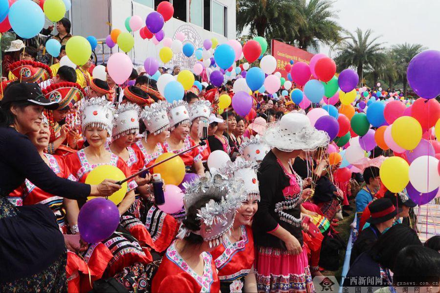 图为开幕式活动现场,不少市民身着壮乡服饰,手持彩球观看表演.