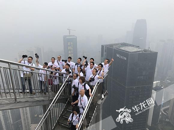 参加摄影拍摄活动的摄影师在解放碑联合国际楼顶合影. 记者 刘嵩 摄