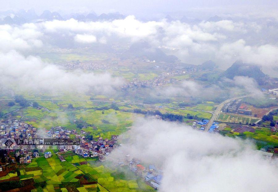 河池市罗城仫佬族自治县东门镇云雾缭绕,黄绿相间的稻田与错落有致的