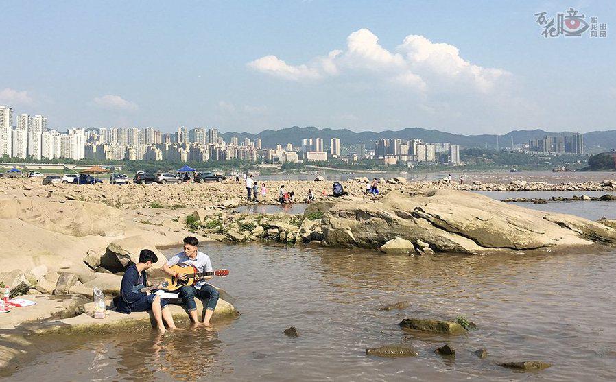 4月29日,重慶南濱路,天氣晴朗,市民在江邊彈奏吉他. 記者 劉嵩 攝