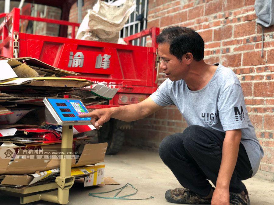 苏琼明将收回来的纸皮称重.广西新闻网记者梁馨予摄