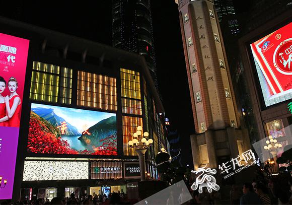 解放碑,led大屏幕上播放"行千里致广大"重庆城市形象广告片.