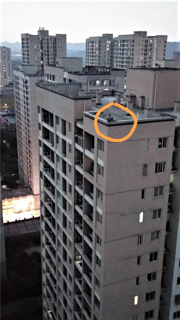 淡定大叔坐在楼顶边沿看风景 对楼小伙误以为想不开赶忙报警