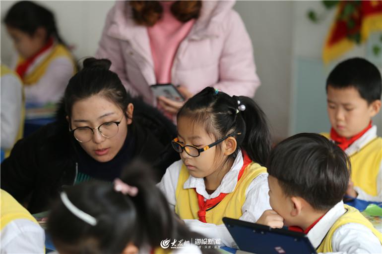 老师在校内辅导学生做家庭作业.