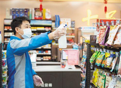 左图 2月3日,温州鹿城区一家超市工作人员为货架消毒.